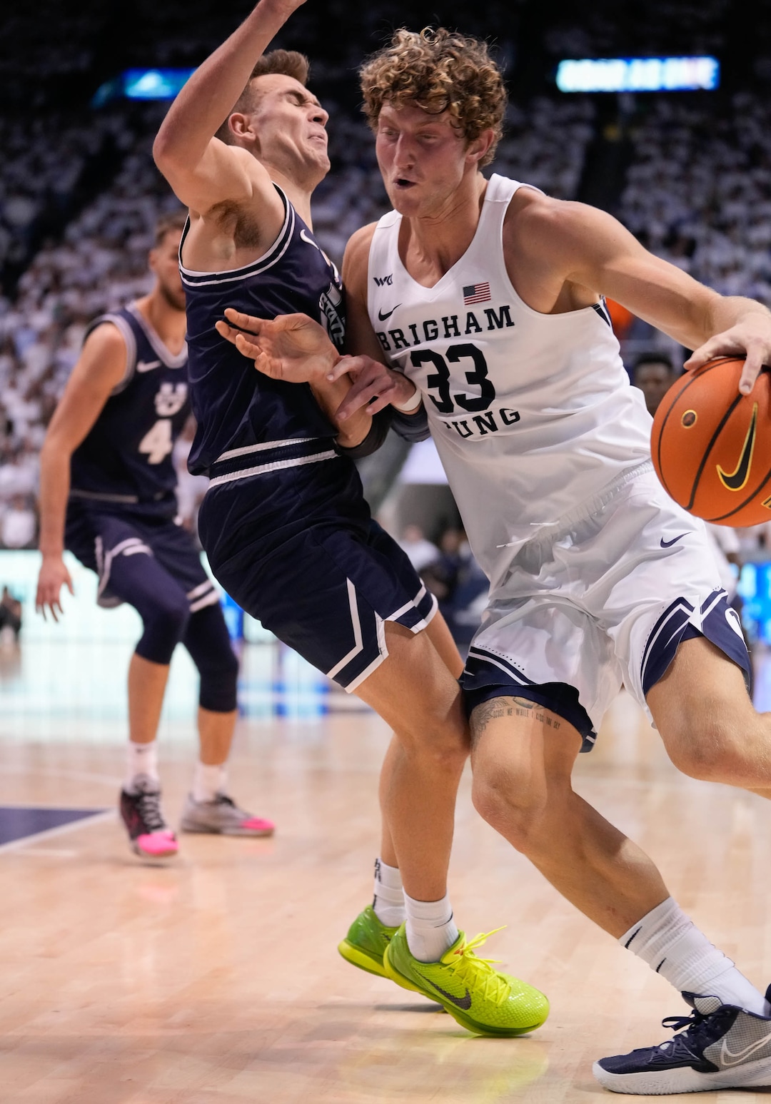 (Francisco Kjolseth | The Salt Lake Tribune) Utah State Aggies guard Steven Ashworth (3) takes a hard hit while defending Brigham Young Cougars forward Caleb Lohner (33) in basketball action between the Brigham Young Cougars and the Utah State Aggies at the Marriott Center in Provo, Wednesday, Dec. 8, 2021.