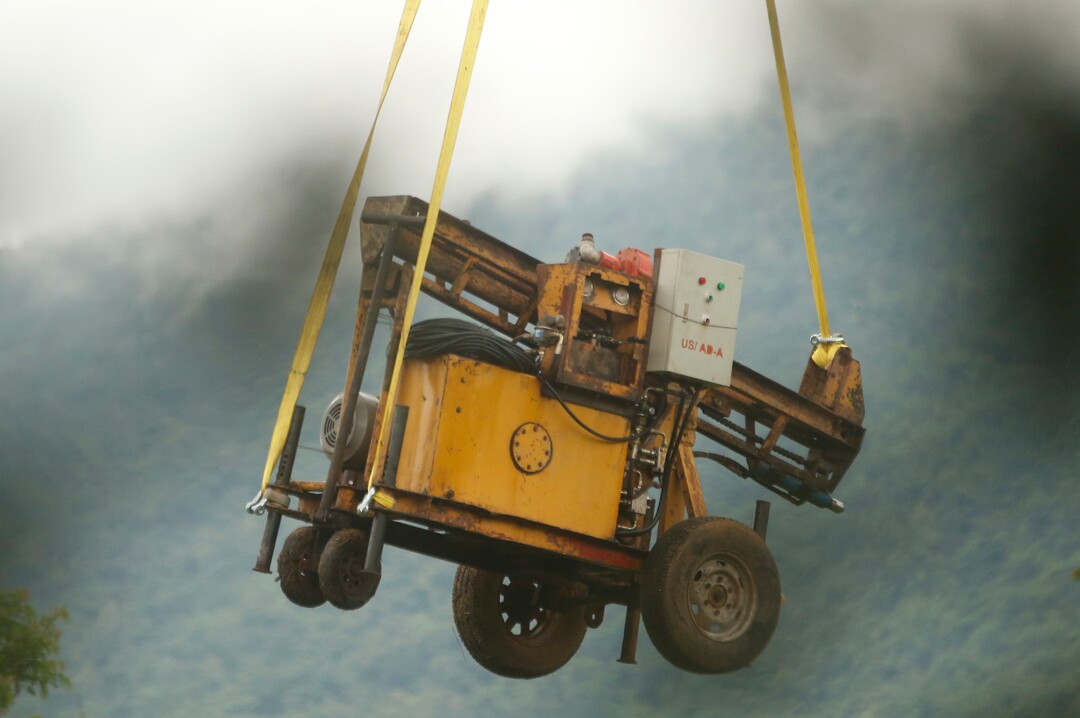 A military transport helicopter carries a drill machine to be used for the rescue search of missing 12 boys and their soccer coach, in Mae Sai, Chiang Rai province, in northern Thailand, Monday, July 2, 2018. Rescue divers are advancing in the main passageway inside the flooded cave in northern Thailand where the boys and their coach have been missing more than a week. (AP Photo/Sakchai Lalit)