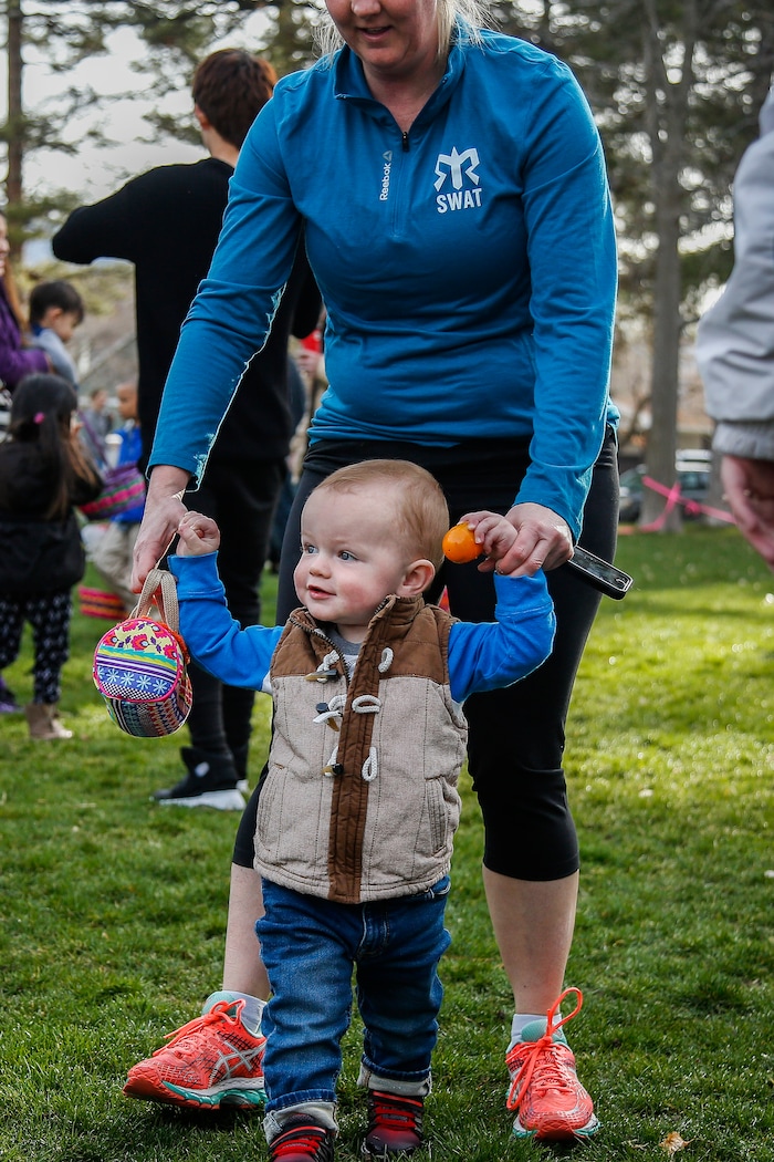 (Nicole Boliaux | For The Tribune) Jennifer Black holds the hands of her nephew Cooper Burdick, helping him hunt for Easter eggs during the annual Easter egg hunt put on by A Kid's Place Dentistry in Liberty Park in Salt Lake City on Saturday, March 31, 2018.