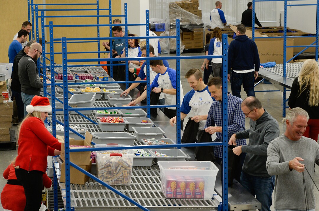 (Francisco Kjolseth  |  The Salt Lake Tribune)  USANA staff volunteer their time assembling food bags for at-risk youth at the newly-renovated packing and storage facility next to the headquarters of the Salt Lake City company on Wed. Dec. 11, 2019. The USANA Foundation has acquired two local charities, Kids Next Door and KidsEat!, that provides hundreds of food bags every week for the kids for the weekends and during long school breaks.
