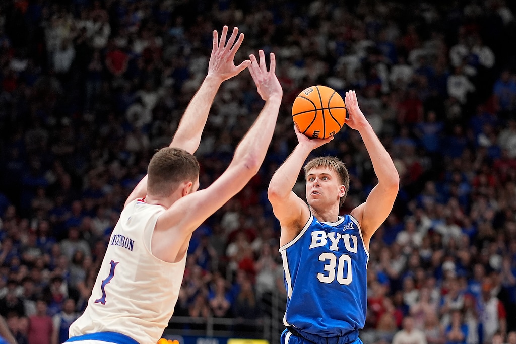 (Charlie Riedel | AP) BYU guard Dallin Hall (30) shoots over Kansas center Hunter Dickinson (1) during the second half of an NCAA college basketball game Tuesday, Feb. 27, 2024, in Lawrence, Kan. BYU won 76-68.
