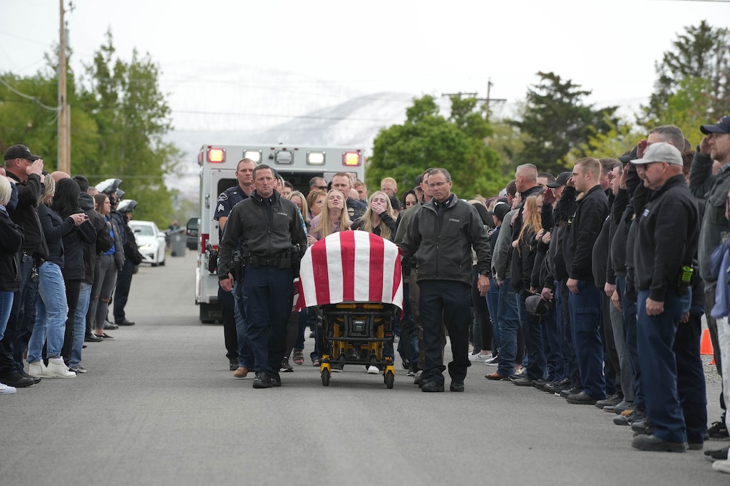 (Chris Samuels  |  The Salt Lake Tribune) Law enforcement and officials form an honor line as the body of a Santaquin police officer killed Sunday is led to a funeral home alongside family members in Santaquin, Monday, May 6, 2024.