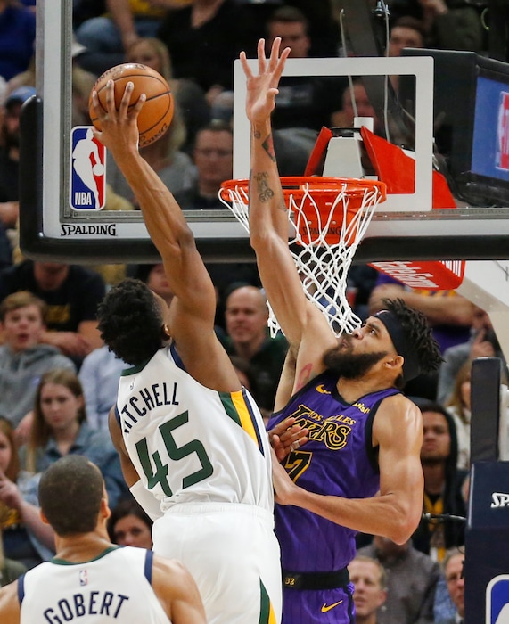Utah Jazz guard Donovan Mitchell (45) dunks on Los Angeles Lakers center JaVale McGee (7) during the first half of an NBA basketball game Friday, Jan. 11, 2019, in Salt Lake City. (AP Photo/Rick Bowmer)