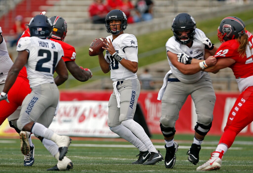 (Andres Leighton | The Associated Press) Utah State quarterback Jordan Love, center, searches for a receiver during the first half of an NCAA college football game against New Mexico in Albuquerque, N.M., Saturday, Nov. 4, 2017.
