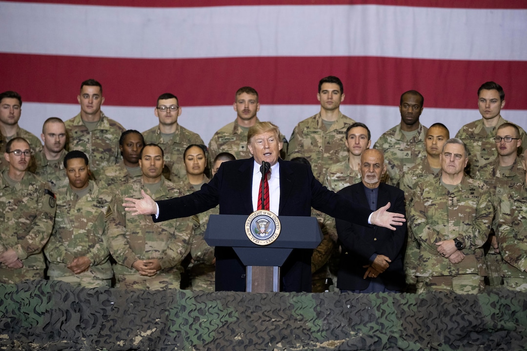 (Alex Brandon | AP) President Donald Trump, center, with Afghan President Ashraf Ghani and Joint Chiefs Chairman Gen. Mark Milley, behind him at right, while addressing members of the military during a surprise Thanksgiving Day visit, Thursday, Nov. 28, 2019, at Bagram Air Field, Afghanistan.