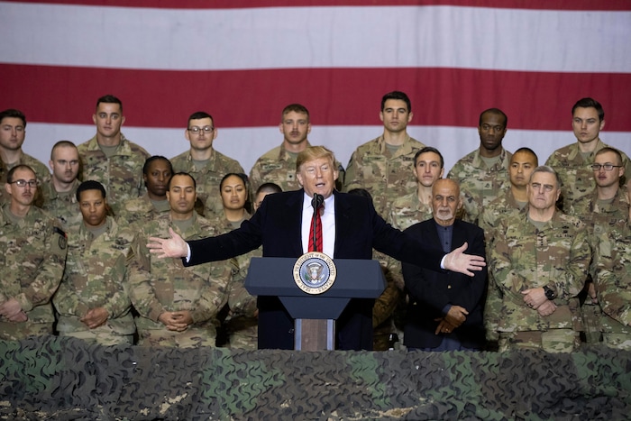 (Alex Brandon | AP) President Donald Trump, center, with Afghan President Ashraf Ghani and Joint Chiefs Chairman Gen. Mark Milley, behind him at right, while addressing members of the military during a surprise Thanksgiving Day visit, Thursday, Nov. 28, 2019, at Bagram Air Field, Afghanistan.