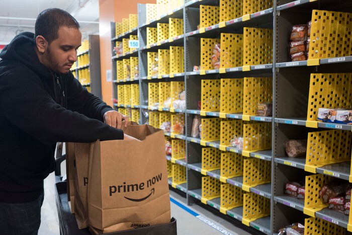 In this Wednesday, Dec. 20, 2017, photo, a clerk fills a customer order at the Amazon Prime warehouse, in New York. (AP Photo/Mark Lennihan)