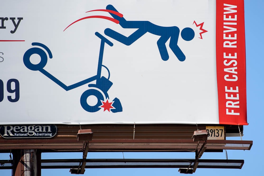 (Trent Nelson | The Salt Lake Tribune)  A billboard advertising legal services along I-15 in Salt Lake City shows a figure flying off a scooter, Monday Sept. 10, 2018.