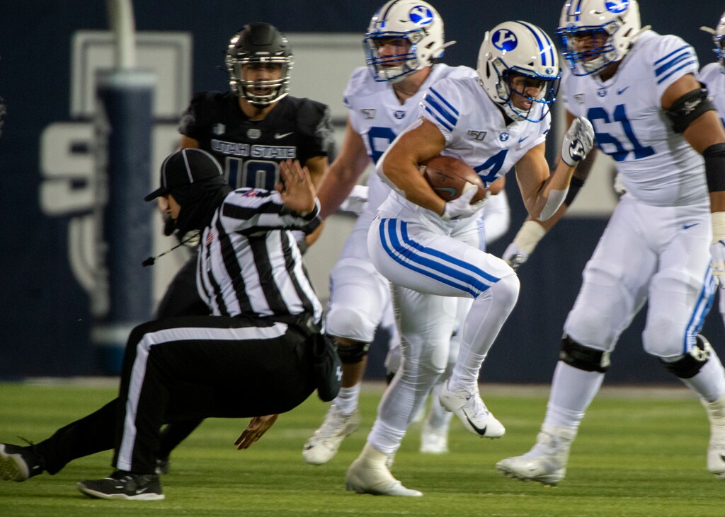 (Rick Egan  |  The Salt Lake Tribune)     Brigham Young Cougars running back Lopini Katoa (4) runs past the official, for a first down, in football action between Brigham Young Cougars and Utah State Aggies in Logan, Saturday, Nov. 2, 2019.