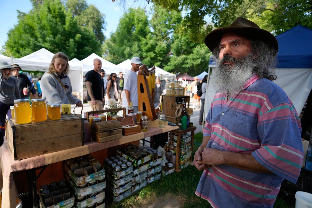 (Francisco Kjolseth | The Salt Lake Tribune) Steven Mountford of White Lake Farm, a 15-year veteran of the Downtown Farmer's Market in Salt Lake City, sells his honey on Saturday, June 7, 2025. A new building is being proposed at the park, designed to house portions of the market and activate the urban park year-round.