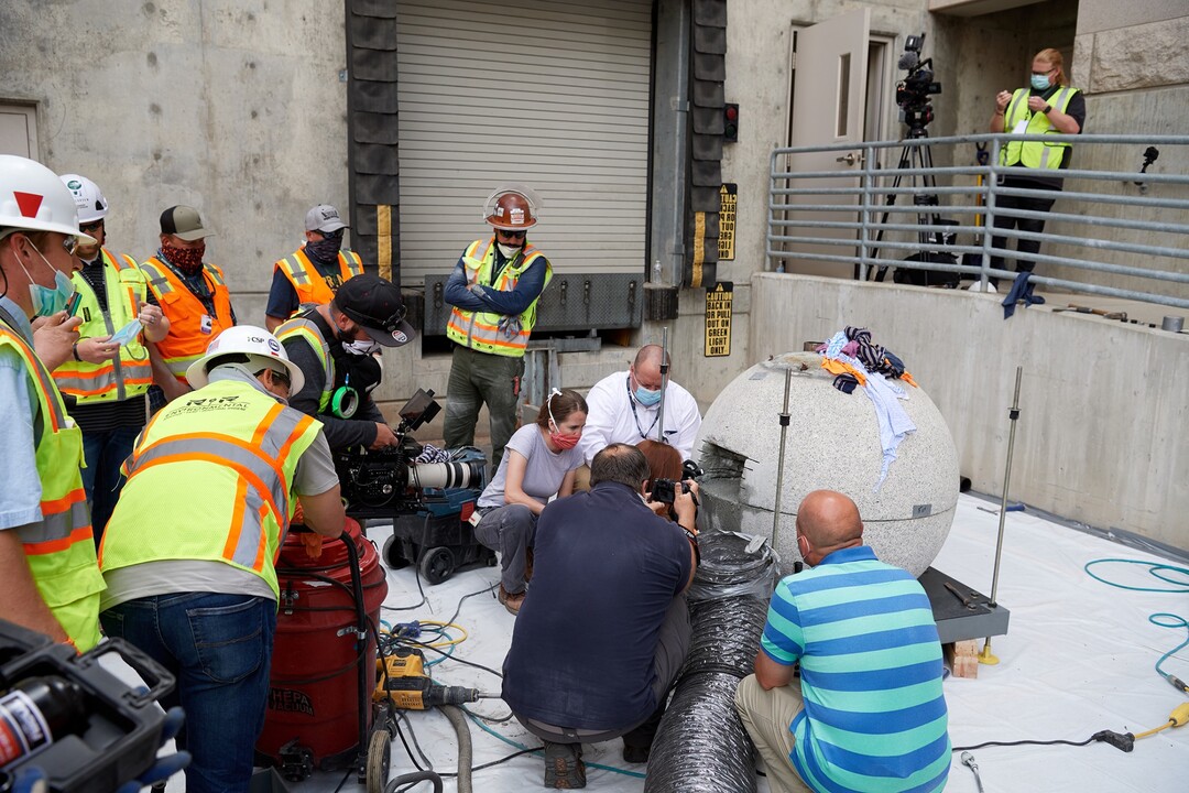 (Photo courtesy of The Church of Jesus Christ of Latter-day Saints) Preservation specialists begin the process of cutting into and retrieving items from the time capsule within the capstone of the Salt Lake Temple on May 18, 2020, at the Church History Library.
