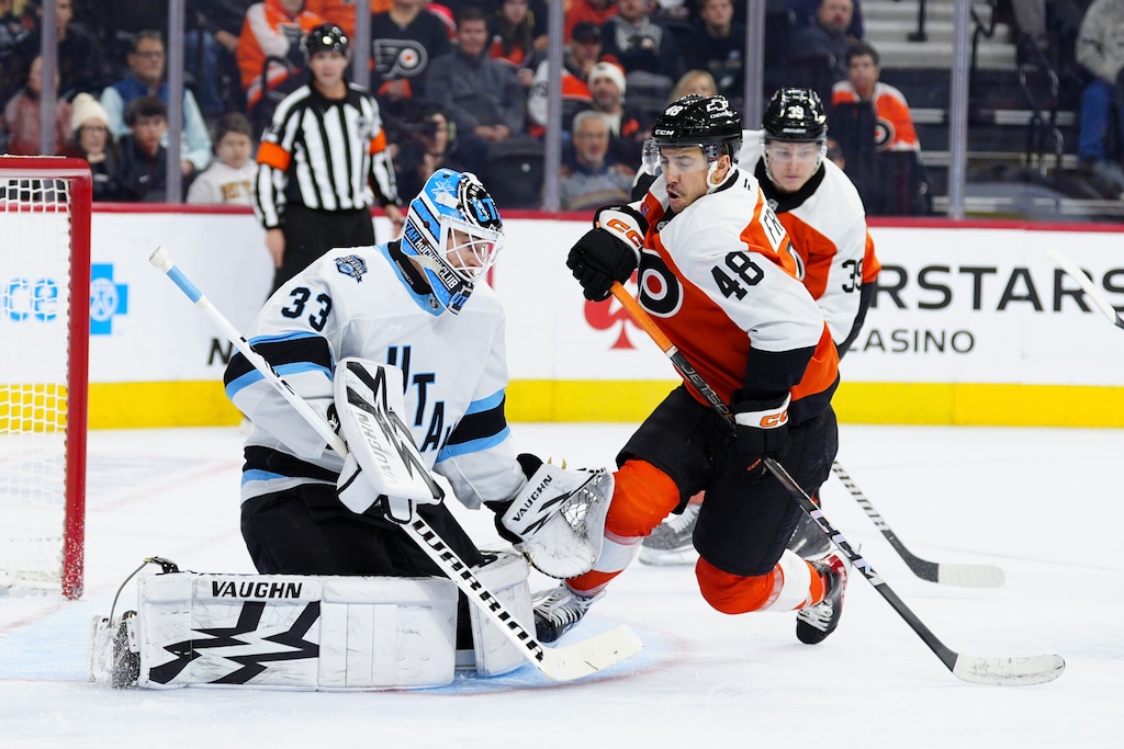 Utah Hockey Club goaltender Jaxson Stauber, left, looks to block a shot past the screen of Philadelphia Flyers' Morgan Frost (48) during the second period of an NHL hockey game, Sunday, Dec. 8, 2024, in Philadelphia. (AP Photo/Derik Hamilton)