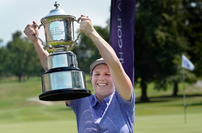 (Scott Sommerdorf   |  The Salt Lake Tribune)   Kelsey Chugg (Weber St.) holds up the winner's trophy after she defeated Anna Kennedy (BYU) to win the 111th Utah Womens State Amateur Championship held at Davis Park Golf Course in Fruit Heights, Friday, August 4, 2017.
