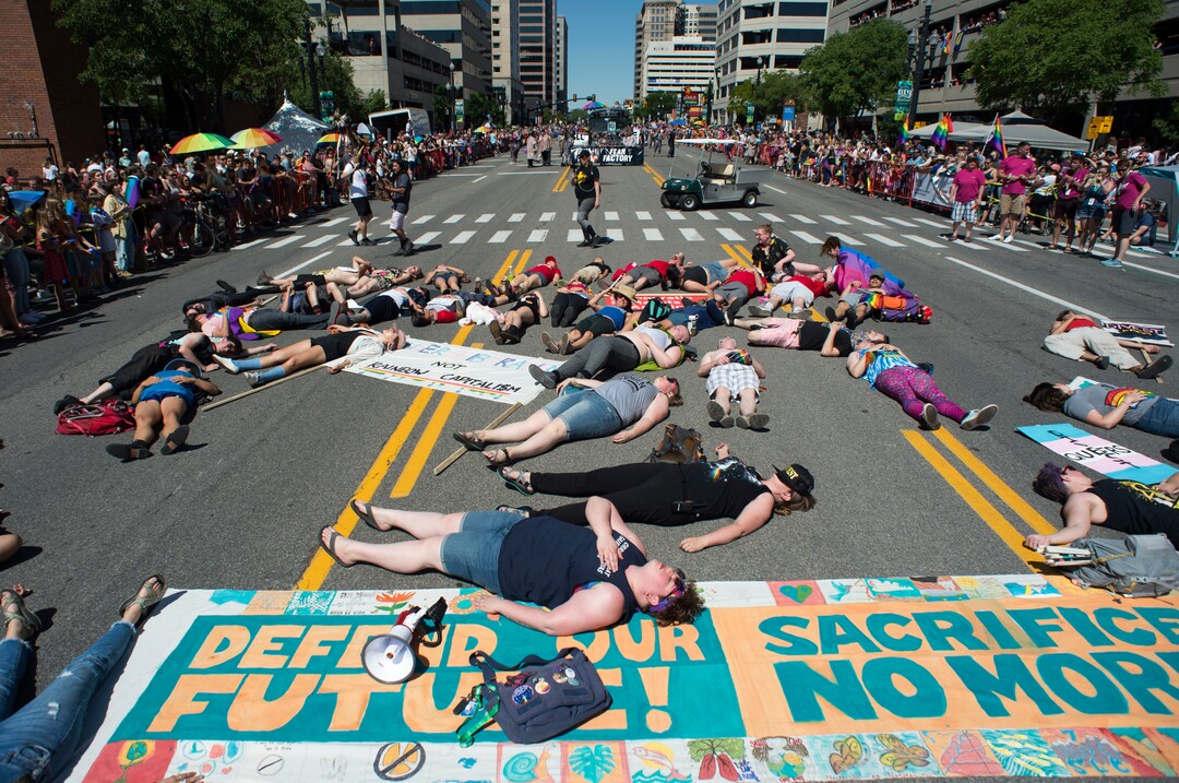 (Rick Egan  |  The Salt Lake Tribune)   The Defend Our Future, Sacrifice No More group delays the parade as they lie down in the street for about 5 minutes, Sunday, June 3, 2018.