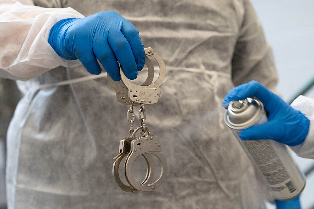 (Francisco Kjolseth | The Salt Lake Tribune) Prison staff at the Utah State Prison in Draper sanitize handcuffs as they work to safely remove inmates from their cells to be vaccinated against COVID-19 on Tuesday, July 27, 2021.