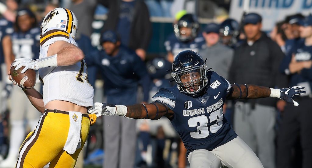 Wyoming quarterback Tyler Vander Waal (18) runs past Utah State linebacker Kevin Meitzenheimer (33) during the first half of an NCAA football game Saturday, Nov. 16, 2019, in Logan, Utah. USU will play one of its Mountain West-high four Thursday-night games this season against Wyoming. (Eli Lucero/The Herald Journal via AP file)