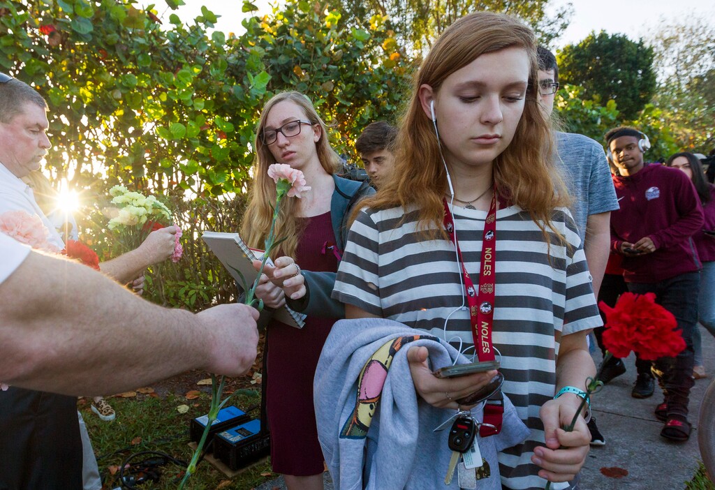 (Matias J. Ocner | Miami Herald | The Associated Press) Students were greeted by supporters, signs and flowers as they returned to class at Marjory Stoneman Douglas High School on Wednesday, Feb. 28, 2018, in Parkland, Fla.  With a heavy police presence, classes resumed for the first time since several students and teachers were killed by a former student on Feb. 14.