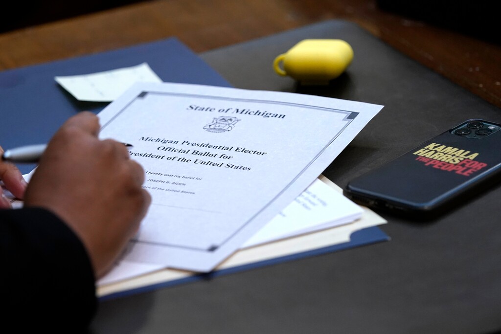 Electoral College elector Marseille Allen signs her ballot for President of the United States at the state Capitol, Monday, Dec. 14, 2020 in Lansing, Mich. (AP Photo/Carlos Osorio, Pool)