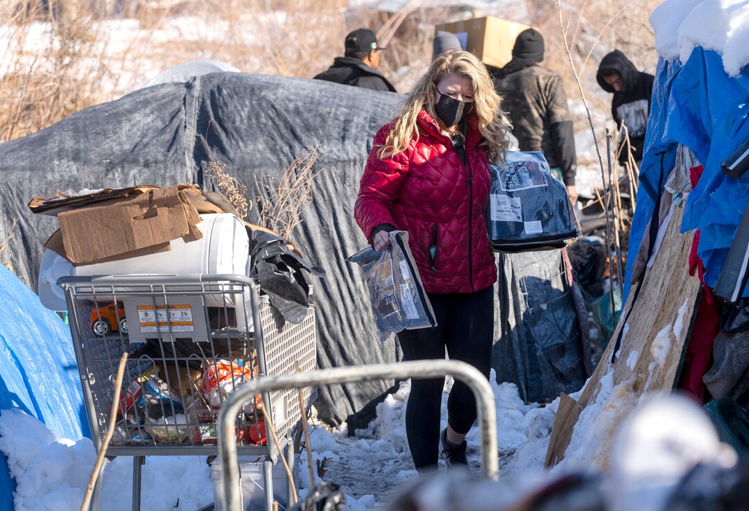 (Rick Egan | The Salt Lake Tribune) Carin Crowe, from Habitat for Humanity, and volunteers from Black Lives for Humanity distribute wool blankets donated by the Sikh community to people in camps in Salt Lake City to help the unsheltered stay warm Thursday, Dec. 23, 2021.