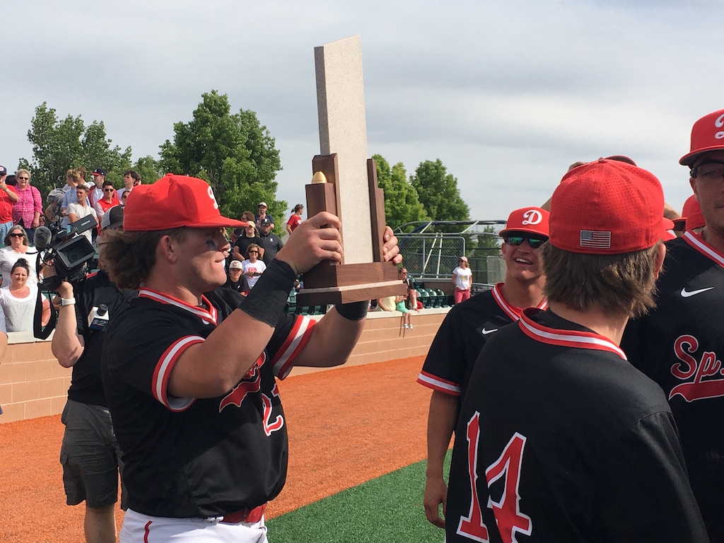 (Eric Butler  |  Special to The Tribune) Spanish Fork senior Hunter Rasmussen takes his turn holding the Class 5A championship trophy after the Dons beat Maple Mountain 14-3 on Saturday.