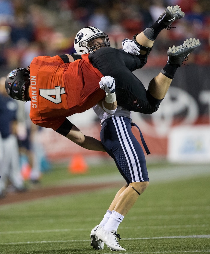 BYU defensive back Micah Hannemann tackles UNLV quarterback Johnny Stanton (4) during an NCAA college football game Friday, Nov. 10, 2017, in Las Vegas. (Erik Verduzco/Las Vegas Review-Journal via AP)