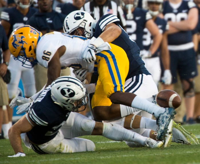 (Rick Egan  |  The Salt Lake Tribune)    Brigham Young Cougars defensive back Austin Kafentzis (24) and linebacker Nate Sampson (50), force a fumble as they hit McNeese State Cowboys wide receiver Rodnell Cruell (86), in football action Brigham Young Cougars vs McNeese State Cowboys at Lavell Edwards Stadium, Saturday, Sept. 22, 2018.


