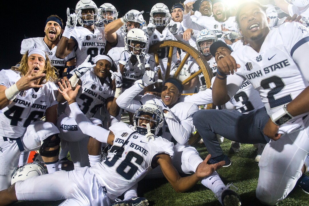 (Chris Detrick  |  The Salt Lake Tribune)  Utah State Aggies pose for pictures with the Old Wagon Wheel after the game at Merlin Olsen Field at Maverik Stadium Friday, September 29, 2017. Utah State Aggies defeated Brigham Young Cougars 40-24.
