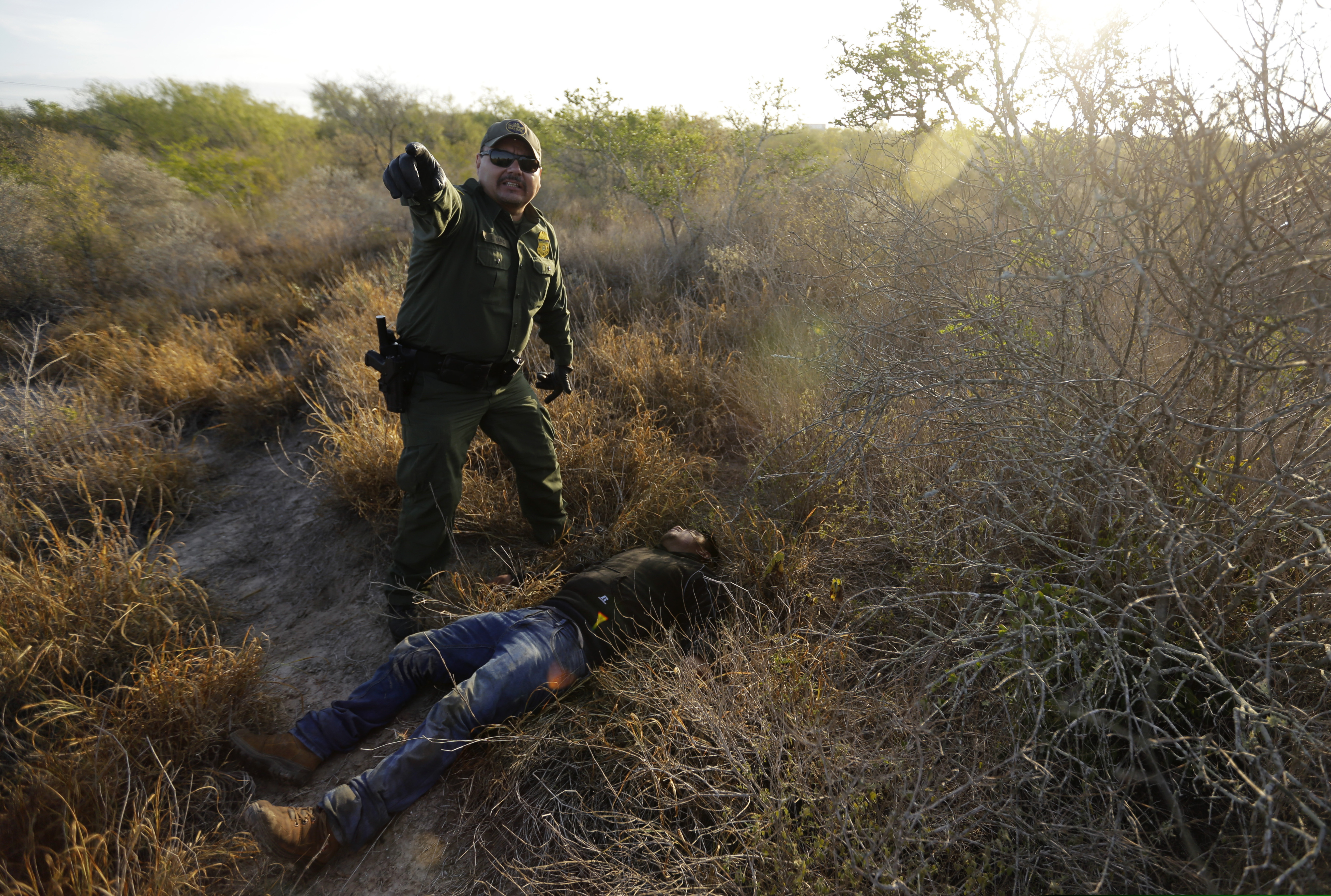 In this Wednesday, Nov. 6, 2019, photo, a Border Patrol agent gives directions to other agents after stopping a man thought to have entered the country illegally, near McAllen, Texas, along the U.S.-Mexico border. In the Rio Grande Valley, the southernmost point of Texas and historically the busiest section for border crossings, the U.S. Border Patrol is apprehending around 300 people daily. That’s down from as many as 2,000 people a day in May. (AP Photo/Eric Gay)