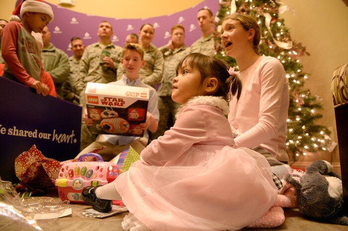 (Al Hartmann  |  The Salt Lake Tribune) 	Adopted foster children, Katie, 2, Ben, 15, and Bonnie Johnston, 14 open Christmas presents  from Airmen from Hill Air Force Base Tuesday Dec. 19. are delivering presents to children in the foster care system. This year, Hill personel will deliver 948 gifts to 326 foster children along the Wasatch Front. 