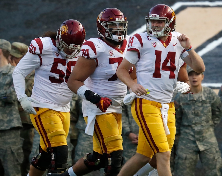 (AP Photo/David Zalubowski) USC quarterback Sam Darnold, right, celebrates after his run for a touchdown with guard Toa Lobendahn, left, and center Nico Falah in the second half of an NCAA college football game against Colorado Saturday, Nov. 11, 2017, in Boulder, Colo. USC won 38-24.