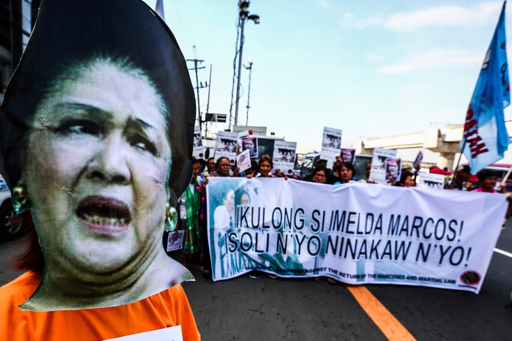 Protesters display a banner as former Philippine First Lady Imelda Marcos was ordered to appear to explain her side for not attending the promulgation of the graft charges against her Friday, Nov. 16, 2018 in suburban Quezon city northeast of Manila, Philippines. A Philippine court found Imelda Marcos guilty of graft. The banner reads: Jail Imelda Marcos! Return The Ill-gotten Wealth.! (AP Photo/Maria S. Tan)