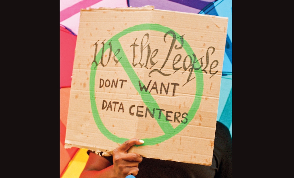 FILE — A demonstrator holds a sign at a data center protest in Kenilworth, N.J., July 18, 2026. (Grade Solomon/The New York Times)
