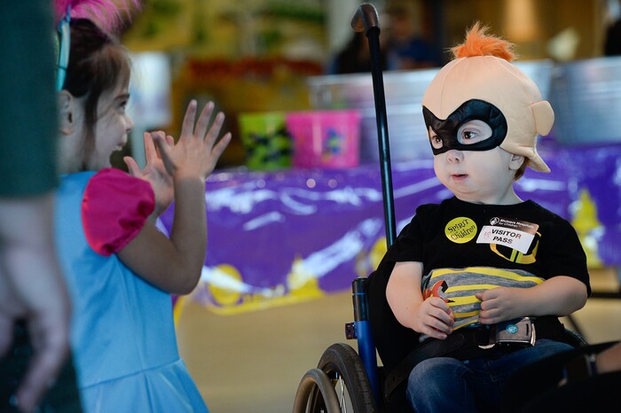 (Francisco Kjolseth  |  The Salt Lake Tribune)  Phyllis Choate, who was celebrating her fifth birthday, engages with Cooper Baskett, 3, dressed as Jack-Jack from "The Incredibles" as they wait for their wheelchairs to be transformed for Halloween. Volunteers and staff at Shriners Hospital for Children in Salt Lake modified the wheelchairs of 28 patients for Halloween, Wednesday, Oct. 17, 2018.