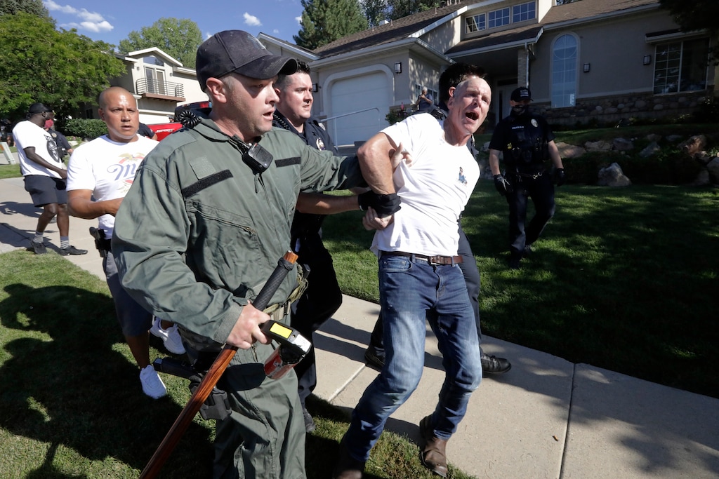 A protester is led away by Cottonwood Heights police officers during a march Sunday, Aug. 2, 2020, in Cottonwood Heights, Utah. The protest was a "March for Justice" focused largely around Zane James, who was fatally shot by police in Cottonwood Heights in 2018. (AP Photo/Rick Bowmer)