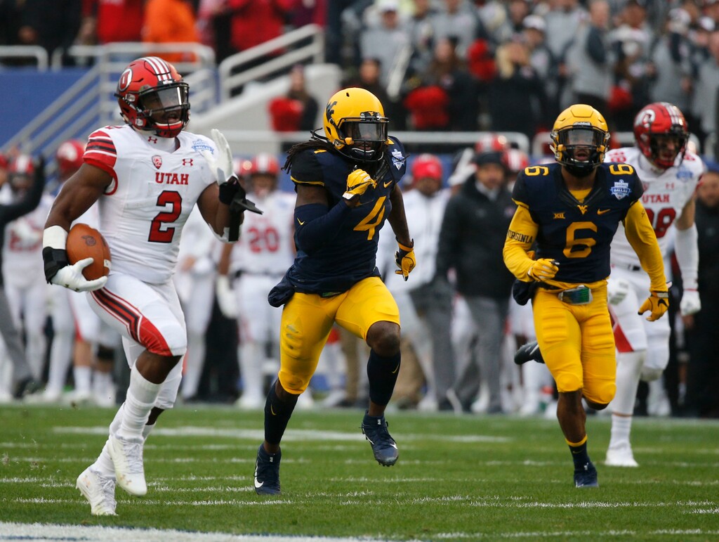 Utah running back Zack Moss (2) runs for a touchdown against West Virginia during Tuesday's first half of the Zaxby's Heart of Dallas Bowl at Cotton Bowl Stadium. (Rose Baca/The Dallas Morning News via AP)