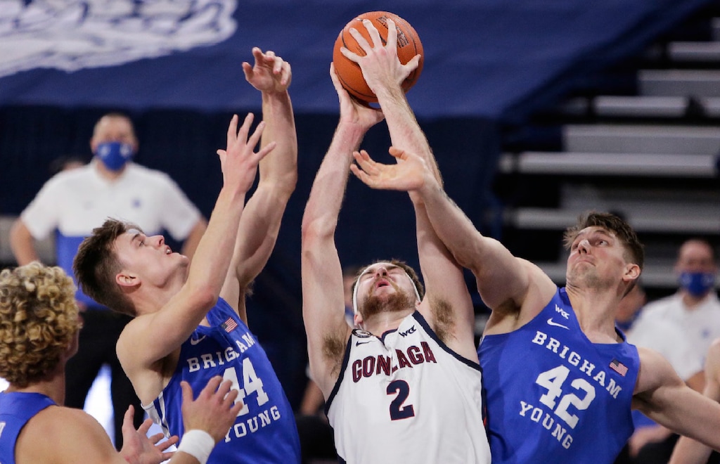Gonzaga forward Drew Timme (2) grabs a rebound between BYU guard Connor Harding (44) and center Richard Harward (42) during the first half of an NCAA college basketball game in Spokane, Wash., Thursday, Jan. 7, 2021. (AP Photo/Young Kwak)