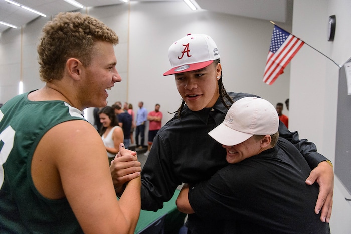 (Trent Nelson  |  The Salt Lake Tribune)  Olympus tight end Cameron Latu embraces teammates after announcing he's headed to Alabama during a news conference at Olympus High School in Salt Lake City Friday August 4, 2017.