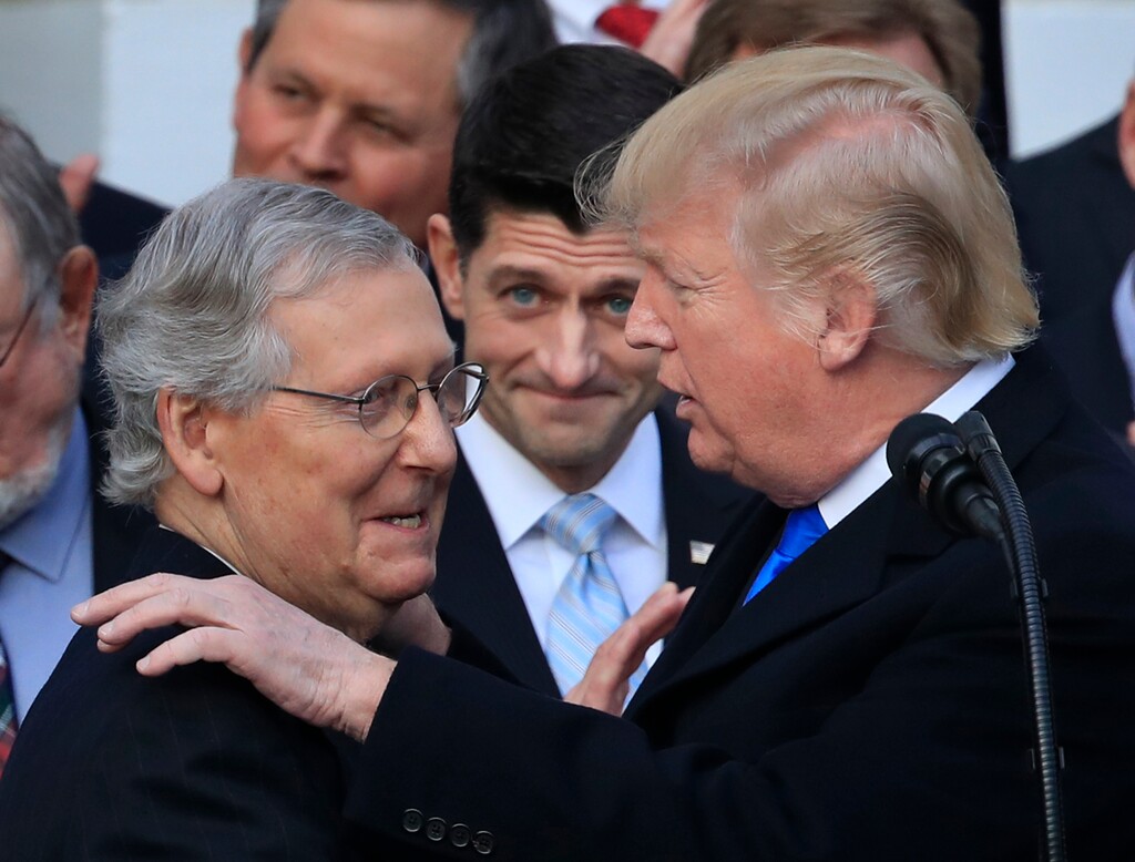 President Donald Trump congratulates Senate Majority Leader Mitch McConnell of Ky., while House Speaker Paul Ryan of Wis., watches to acknowledge the final passage of tax overhaul legislation by Congress at the White House in Washington, Wednesday, Dec. 20, 2017. (AP Photo/Manuel Balce Ceneta)