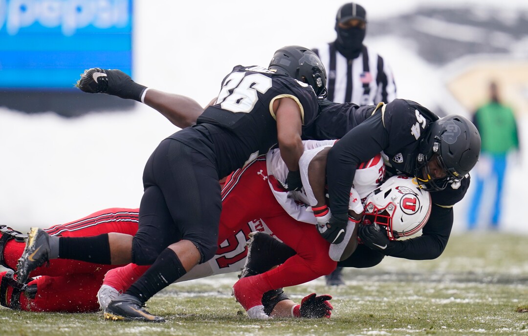 Utah wide receiver Kyrese Rowan, bottom right, is stopped by Colorado defensive end Terrance Lang, top right, and linebacker Akil Jones during the first half of an NCAA college football game Saturday, Dec. 12, 2020, in Boulder, Colo. (AP Photo/David Zalubowski)