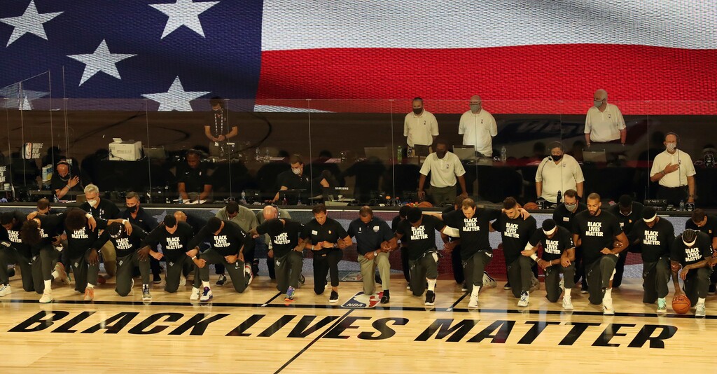 (Charles King | Orlando Sentinel via AP file photo)  Players and coaches kneel during the national anthem before the Utah Jazz against the New Orleans Pelicans NBA basketball game Thursday, July 30, 2020, in Lake Buena Vista, Fla.