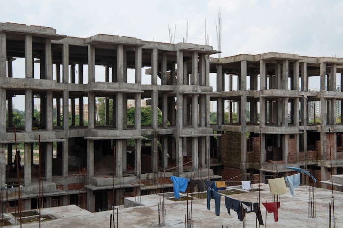 (Saumya Khandelwal | The New York Times) A government housing project under construction, where many laborers both work and live, in Lucknow, India, July 27, 2020. Around the world, the poor and marginalized are much more likely to be vulnerable to extreme heat; the Dalits laboring here are at the bottom of the Hindu caste ladder and have their left their home villages in search of work.