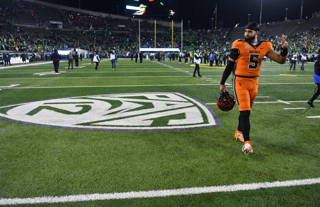 (Mark Ylen | AP) Former Oregon State quarterback DJ Uiagalelei (5) walks by the Pac-12 logo and waves to fans after the team's NCAA college football game against Oregon, Friday, Nov. 24, 2023, in Eugene, Ore. 