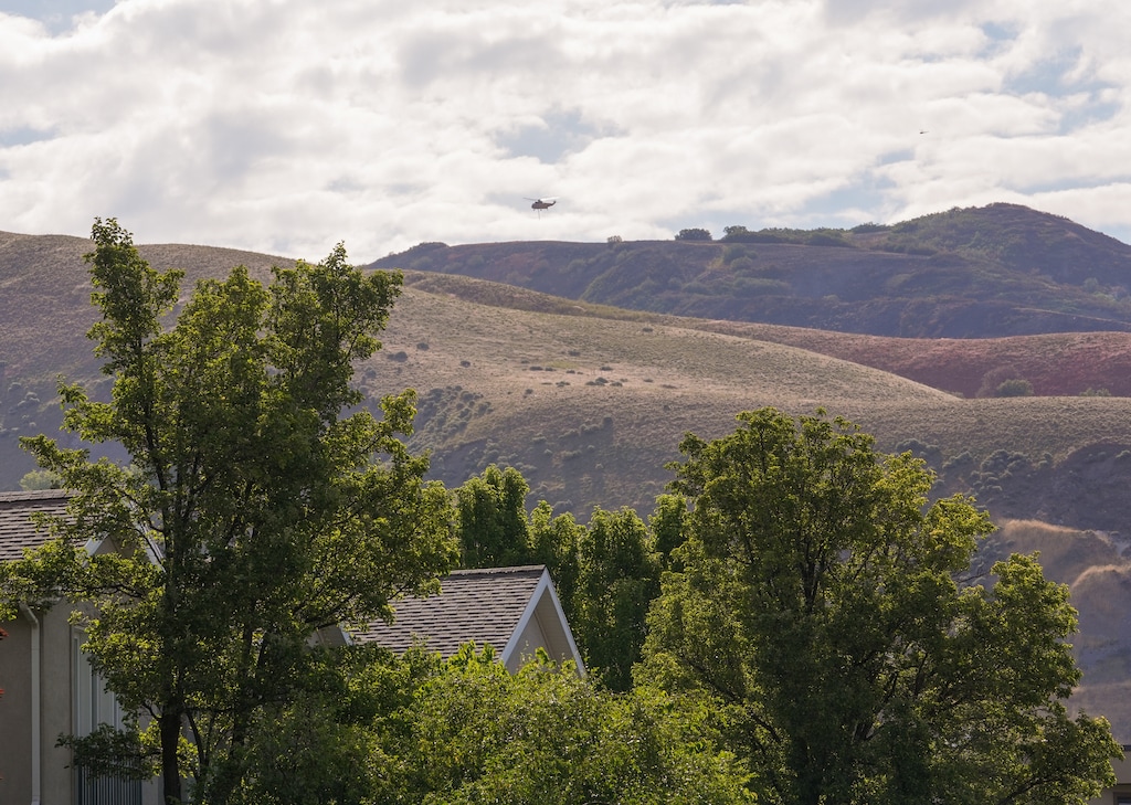 (Chris Samuels | The Salt Lake Tribune) A helicopter circles the Bonneville Fire near the Arlington Hills neighborhood in Salt Lake City, Monday, June 22, 2026. Early Tuesday, officials announced there was "no longer an immediate threat with this fire."
