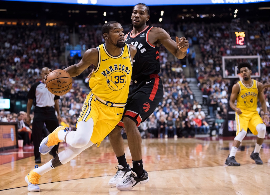 Golden State Warriors forward Kevin Durant (35) drives around Toronto Raptors forward Kawhi Leonard (2) during the second half of an NBA basketball game Thursday, Nov. 29, 2018, in Toronto. (Nathan Denette/The Canadian Press via AP)