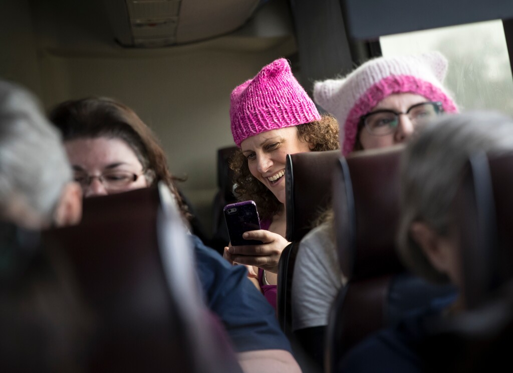 Katrina Bucknell chats with her seatmate while wearing a hat on a bus from Minnesota to Washington for the Women's March, Friday, Jan. 20, 2016, in Wisconsin. (Renee Jones Schneider/Star Tribune via AP)