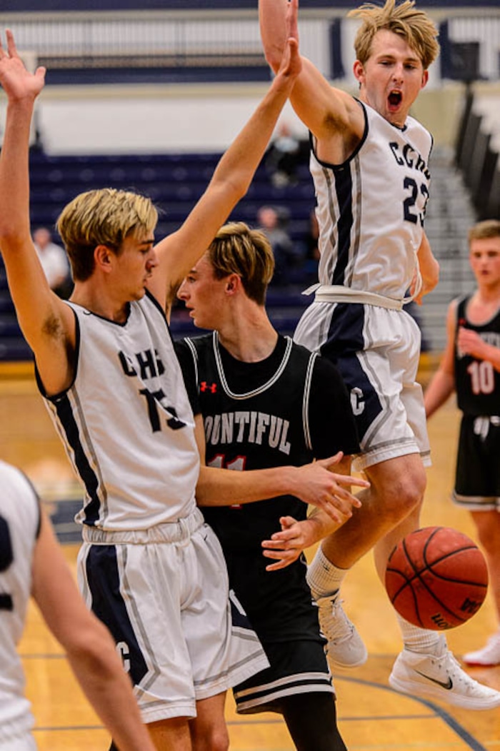 (Trent Nelson | The Salt Lake Tribune)  Bountiful's Garrett Buchanan (11) makes a no-look pass, as Corner Canyon's Shane Hertgen (15) and Corner Canyon's Blake Emery (23) defend, as Corner Canyon faces Bountiful in the title game of the Corner Canyon Tournament of Champions, high school boys' basketball in Draper, Saturday December 2, 2017.