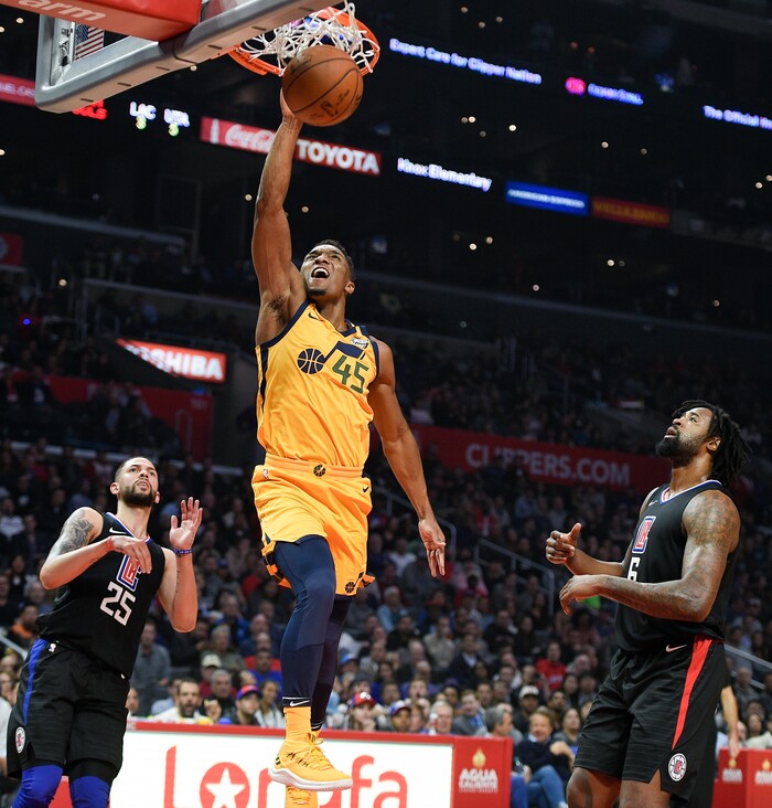 Utah Jazz guard Donovan Mitchell dunks between Los Angeles Clippers guard Austin Rivers, left, and center DeAndre Jordan during the first half of an NBA basketball game in Los Angeles, Thursday, Nov. 30, 2017. (AP Photo/Kelvin Kuo)