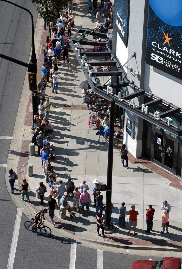 (Scott Sommerdorf | The Salt Lake Tribune) Hundreds of hopeful eclipse-watchers line up in a line that was doubled back upon itself as it stretched around the corner outside the Clark Planetarium. They all were hoping to get eclipse glasses from the gift shop, Thursday, August 17, 2017.