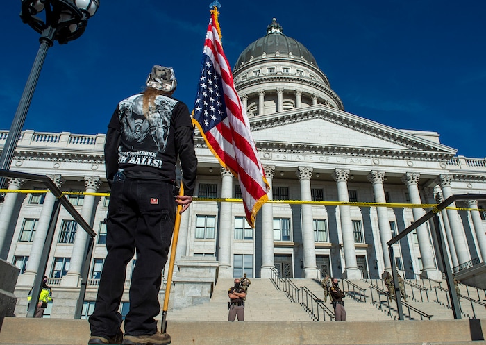 (Rick Egan | The Salt Lake Tribune) One of a dozen protesters carries an upside down flag at the Utah Capitol around noon on Sunday, Jan. 17, 2021.