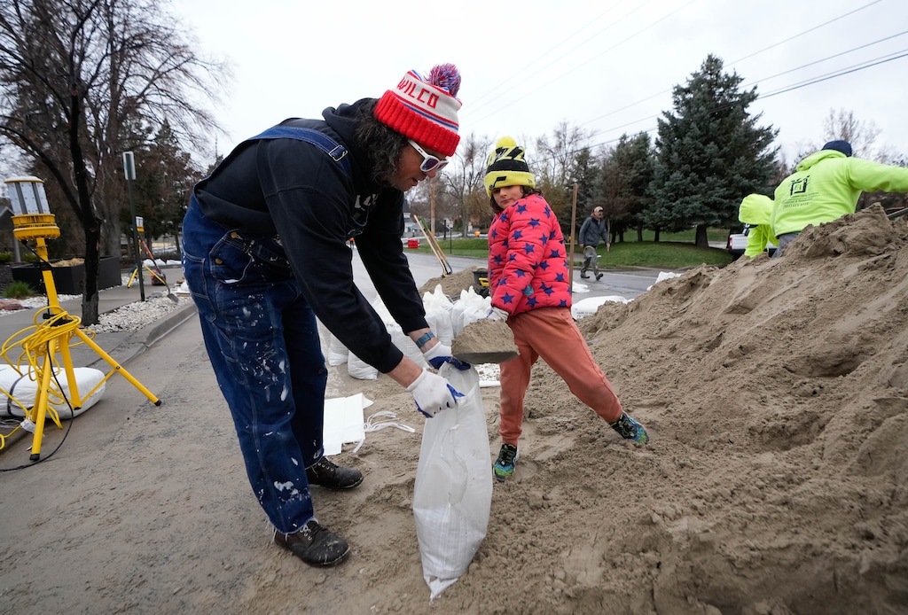 (Francisco Kjolseth | The Salt Lake Tribune) Nick Steffens is joined by his daughter Des, 8, as they volunteer filling sandbags near Wasatch Hollow Park in Salt Lake City on Thursday, April 13, 2023.